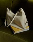 White handbag on a stack of books with a dark background